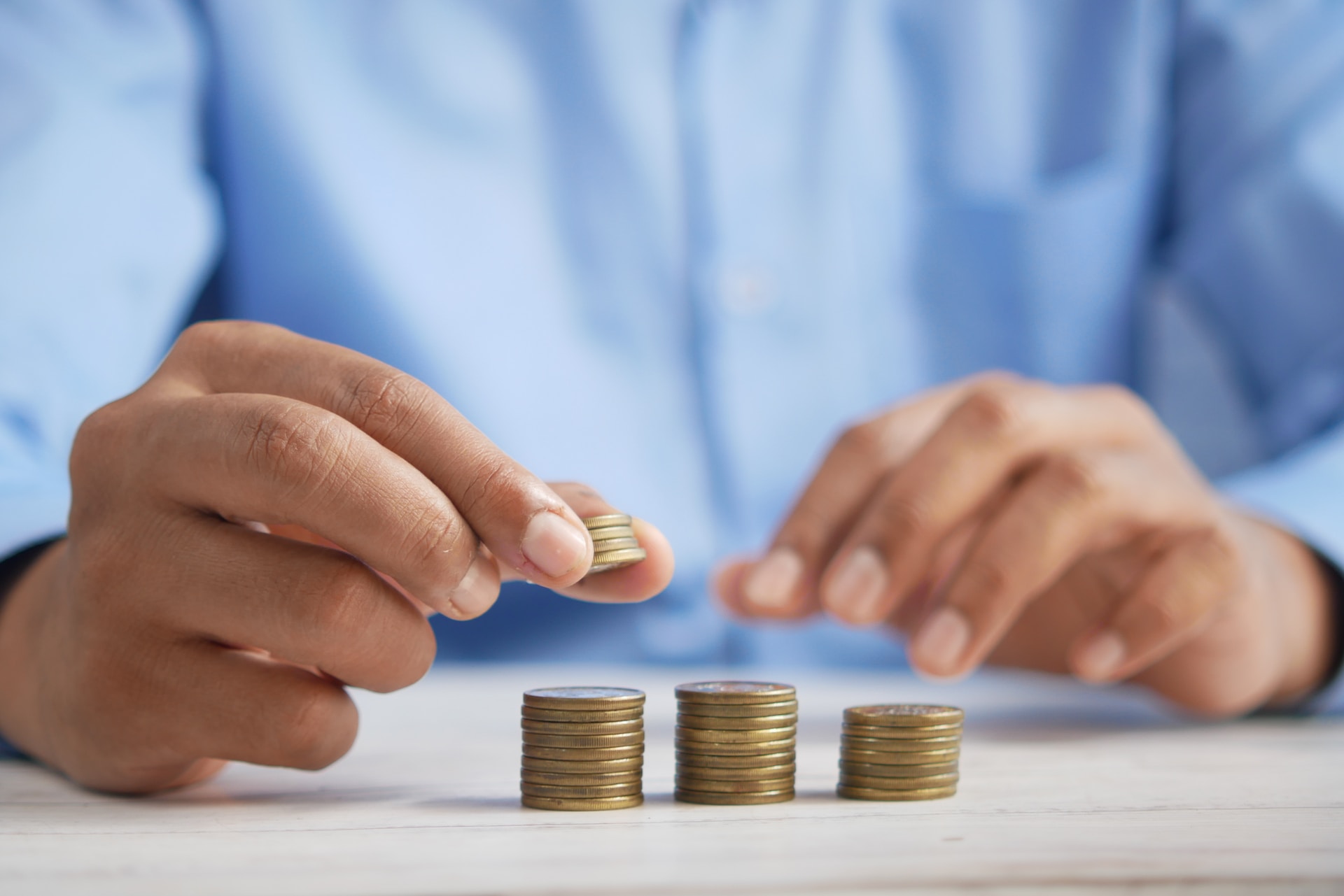 Mains au-dessus de pièces de monnaie, illustration du coût de l’assurance de prêt