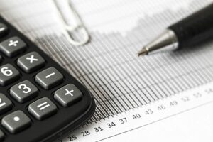 Calculatrice, graphique financier et stylo illustrant l’analyse d’un avis d’impôt 2026