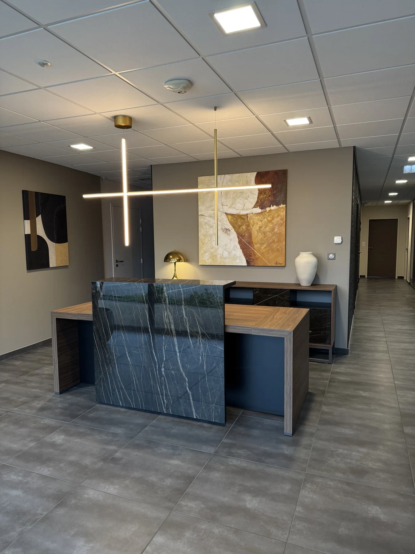 Accueil du cabinet avec banque en marbre bleu et suspension dorée