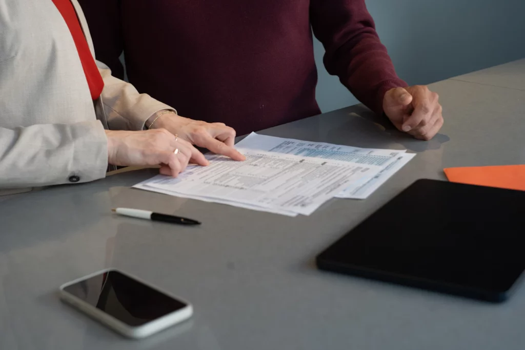Deux personnes examinent des documents autour d’une table