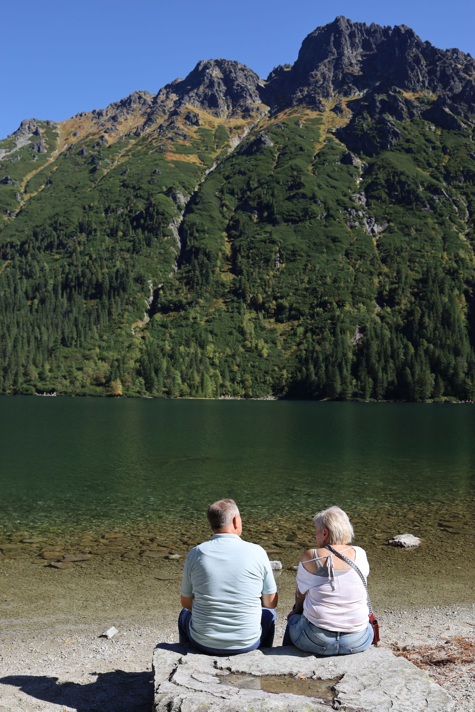 Couple préparant sa retraite face à un lac de montagne